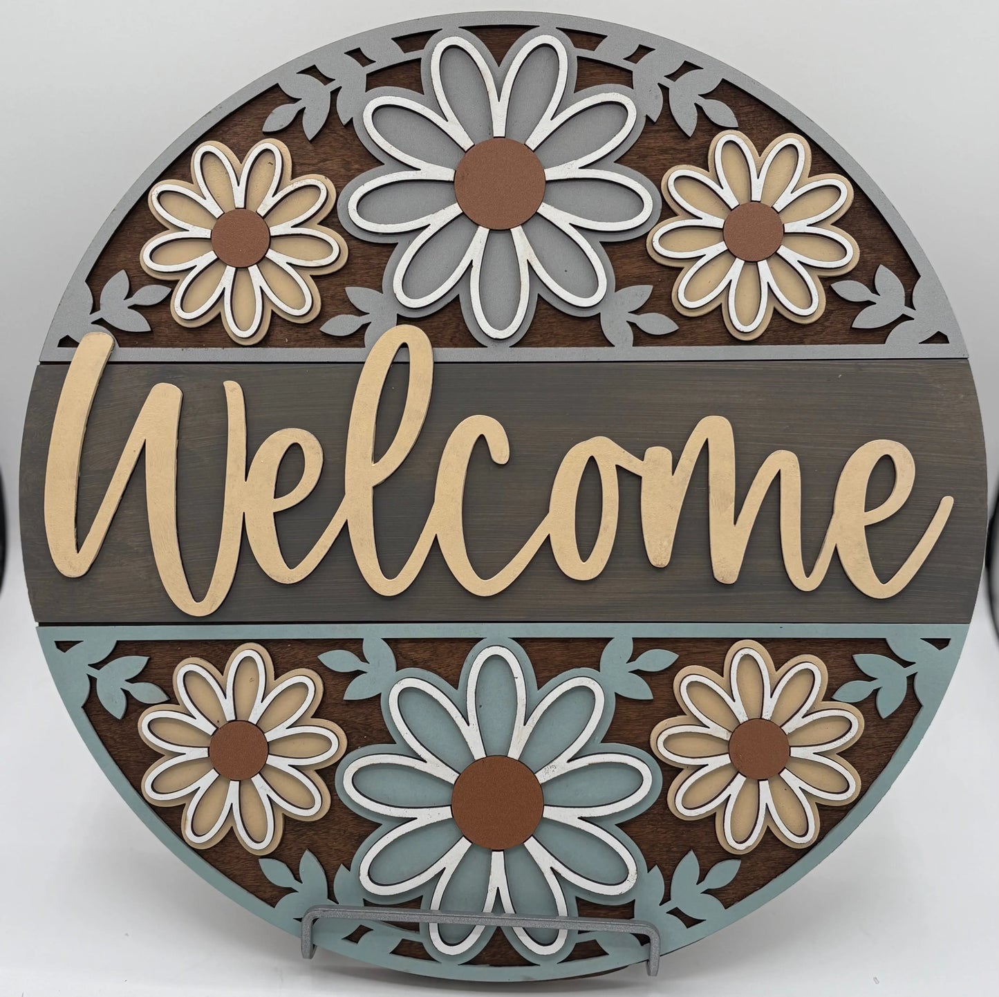 Decorative round sign with flowers and the word 'Welcome' on a white background