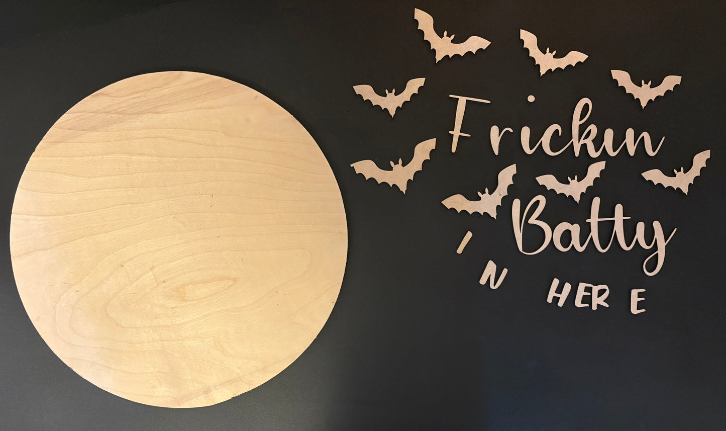 Wooden moon-shaped board with bats and text 'Frickin Batty in here' on a black background