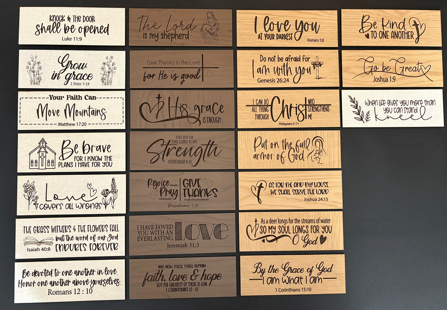 Collection of wooden plaques with engraved text and designs on a dark background