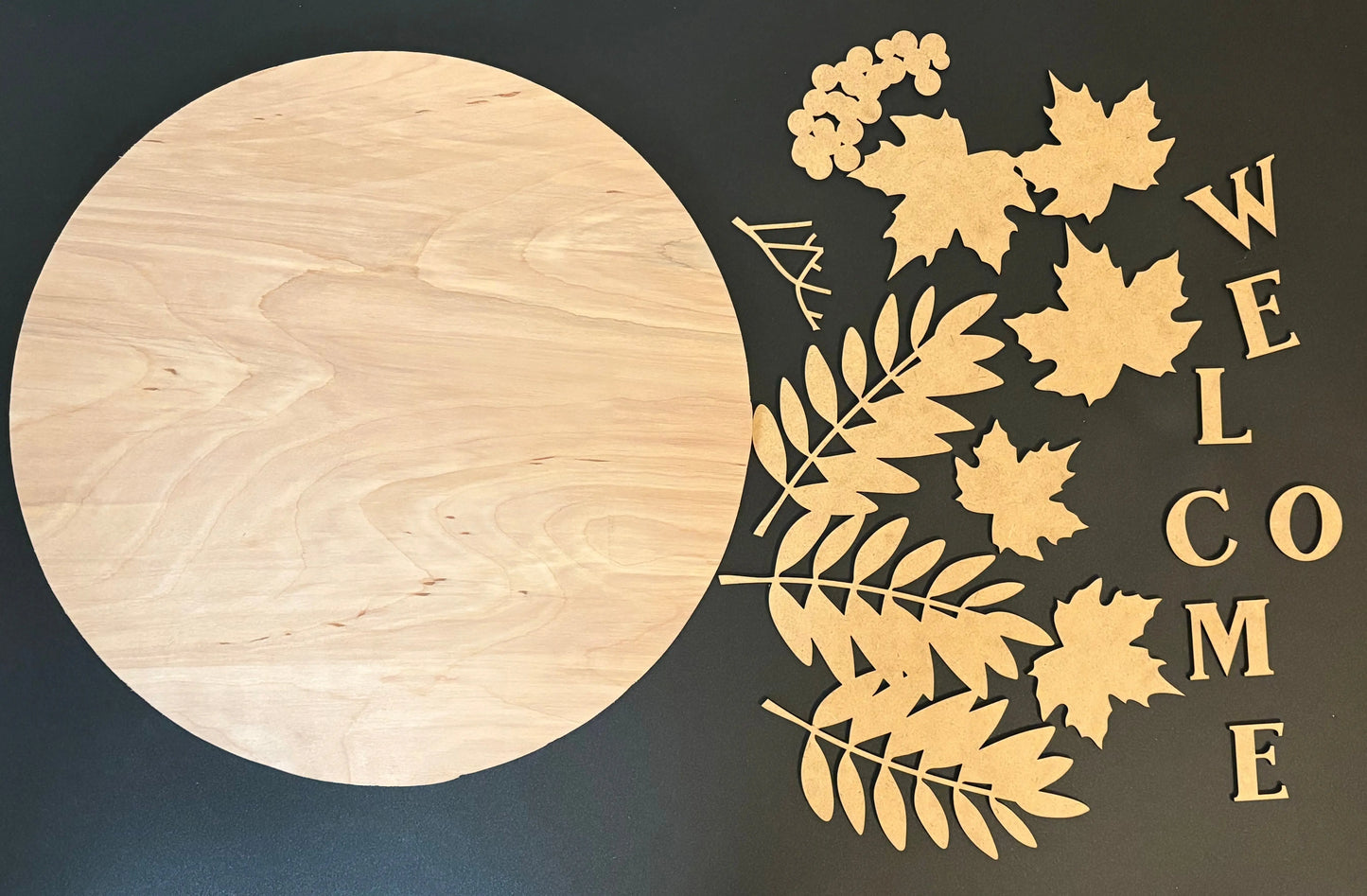 Decorative wooden sign with leaves and 'WELCOME' text on a dark background
