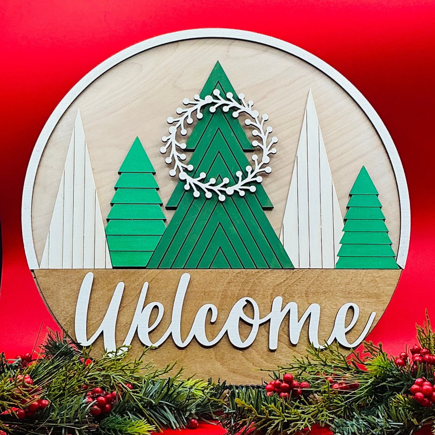 Decorative sign with Christmas trees and 'Welcome' text on a red background