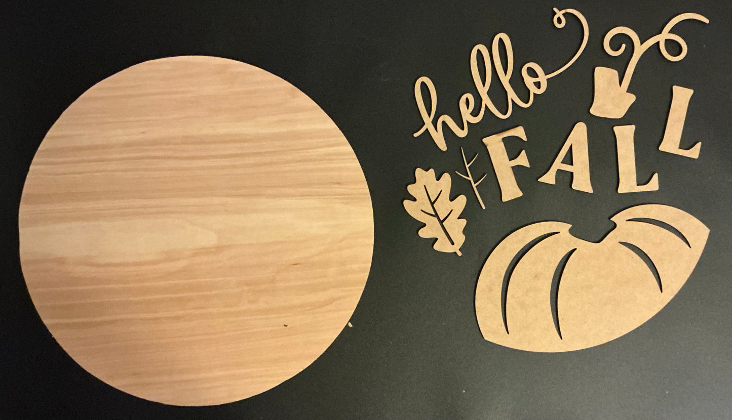 Wooden round sign with 'hello Fall' and pumpkin decorations on a black background