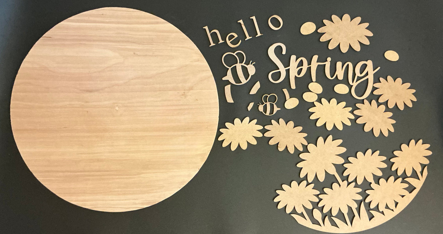 Wooden cutouts with 'hello Spring' text and floral designs on a dark background