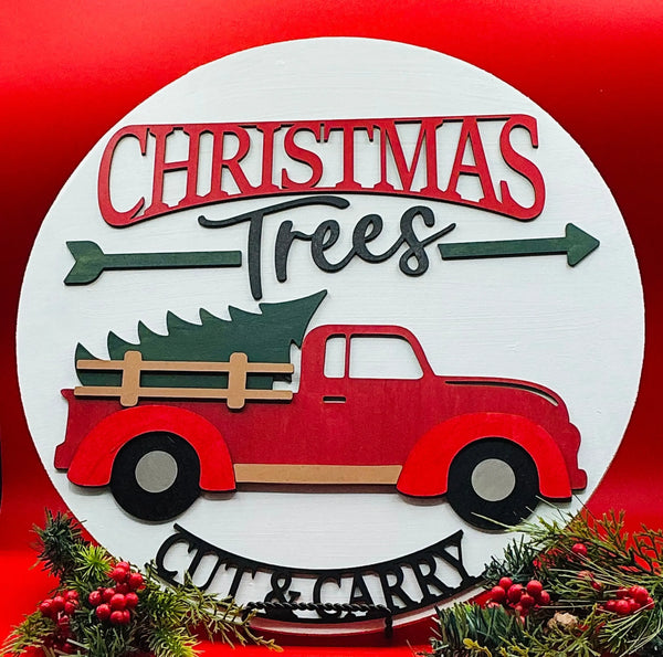 Decorative sign with a red truck carrying a Christmas tree on a white background