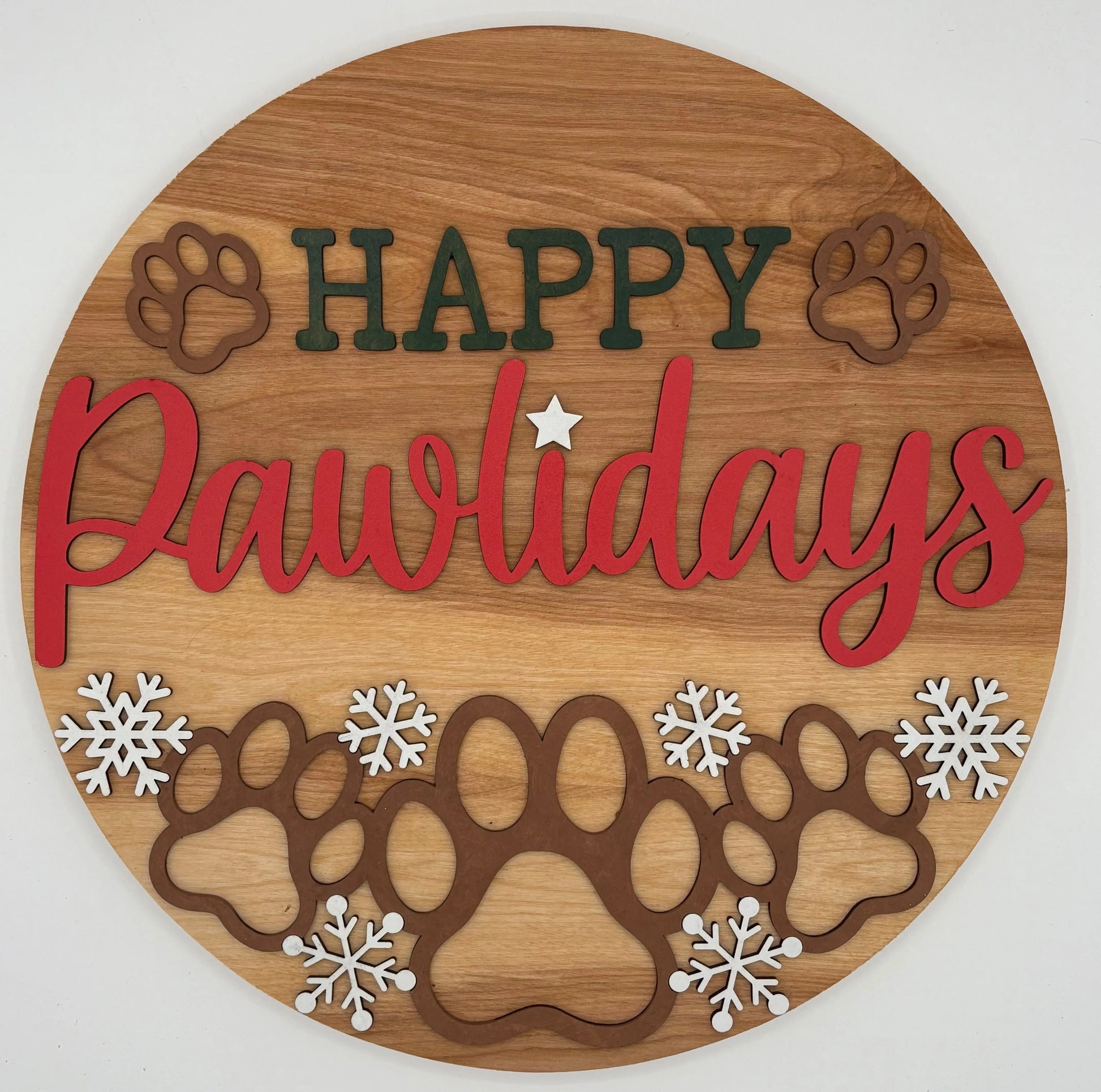 Wooden circular sign with 'Happy Pawlidays' text and paw prints on a white background