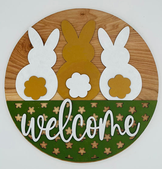 Welcome sign featuring three bunnies in white and gold with green accents for home decor.