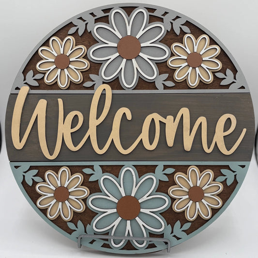 Decorative round sign with flowers and the word 'Welcome' on a white background