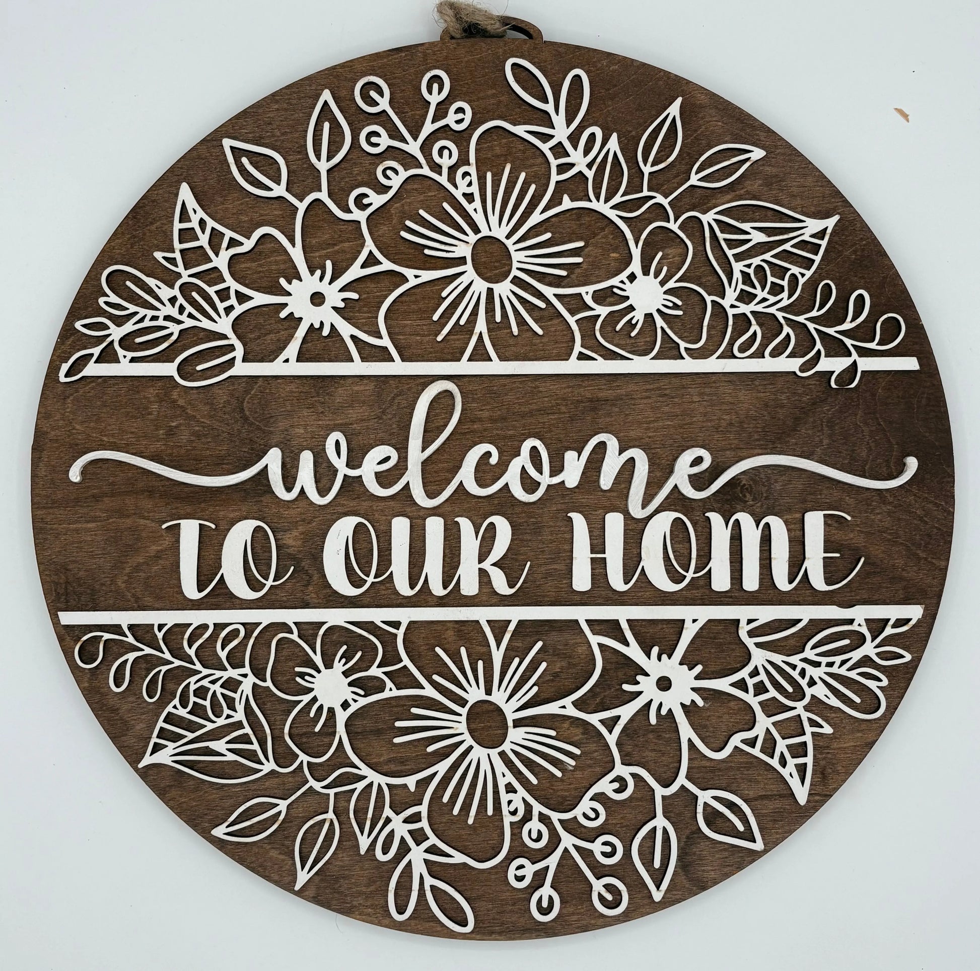 Decorative wooden sign with floral patterns and 'Welcome to our Home' text on a white background