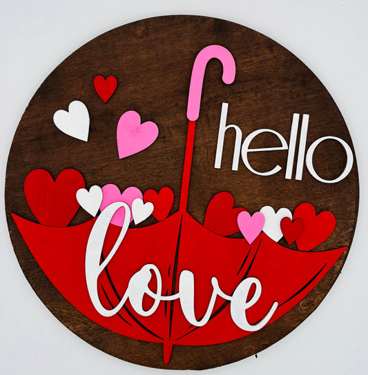 A decorative umbrella with the words 'hello' and 'love' written in a cursive and playful font, accompanied by various heart shapes in shades of pink and white.