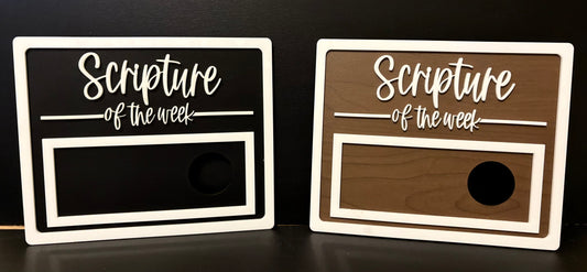 Two wooden signs with 'Scripture of the week' text on a black background