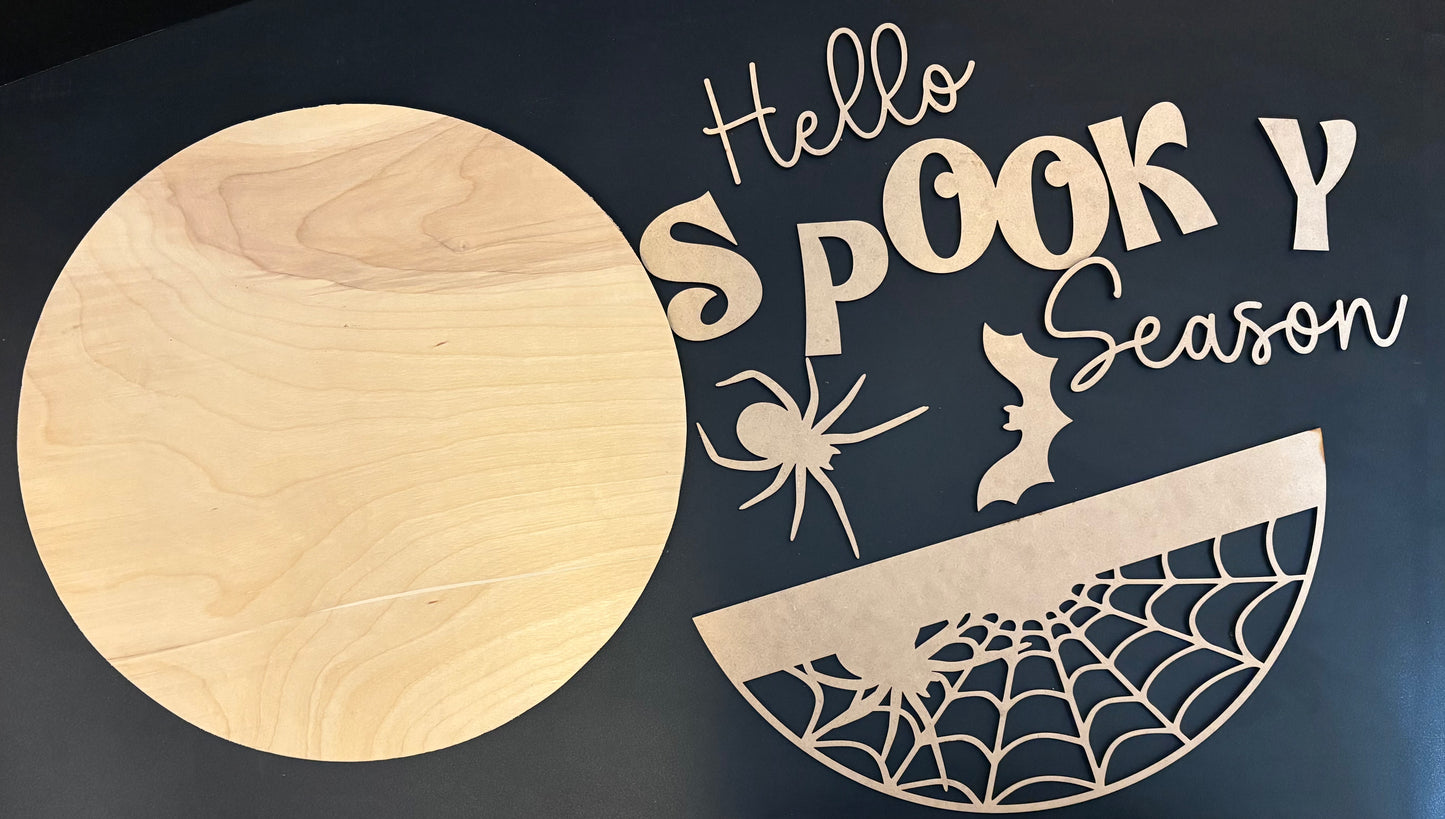 circular sign with "hello spooky season" with spider and bat