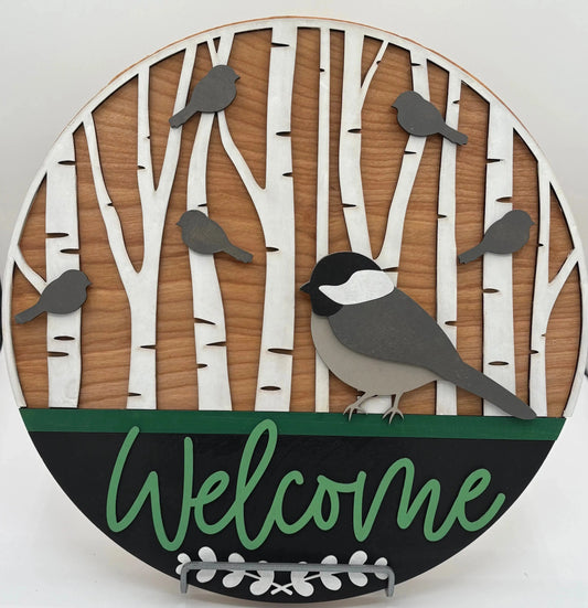 Decorative wall art with birds and 'Welcome' text on a wooden background