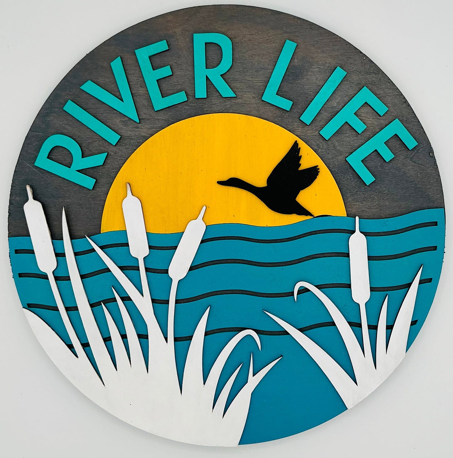 Decorative sign with 'River Life' text, duck, and nature elements on a circular background.