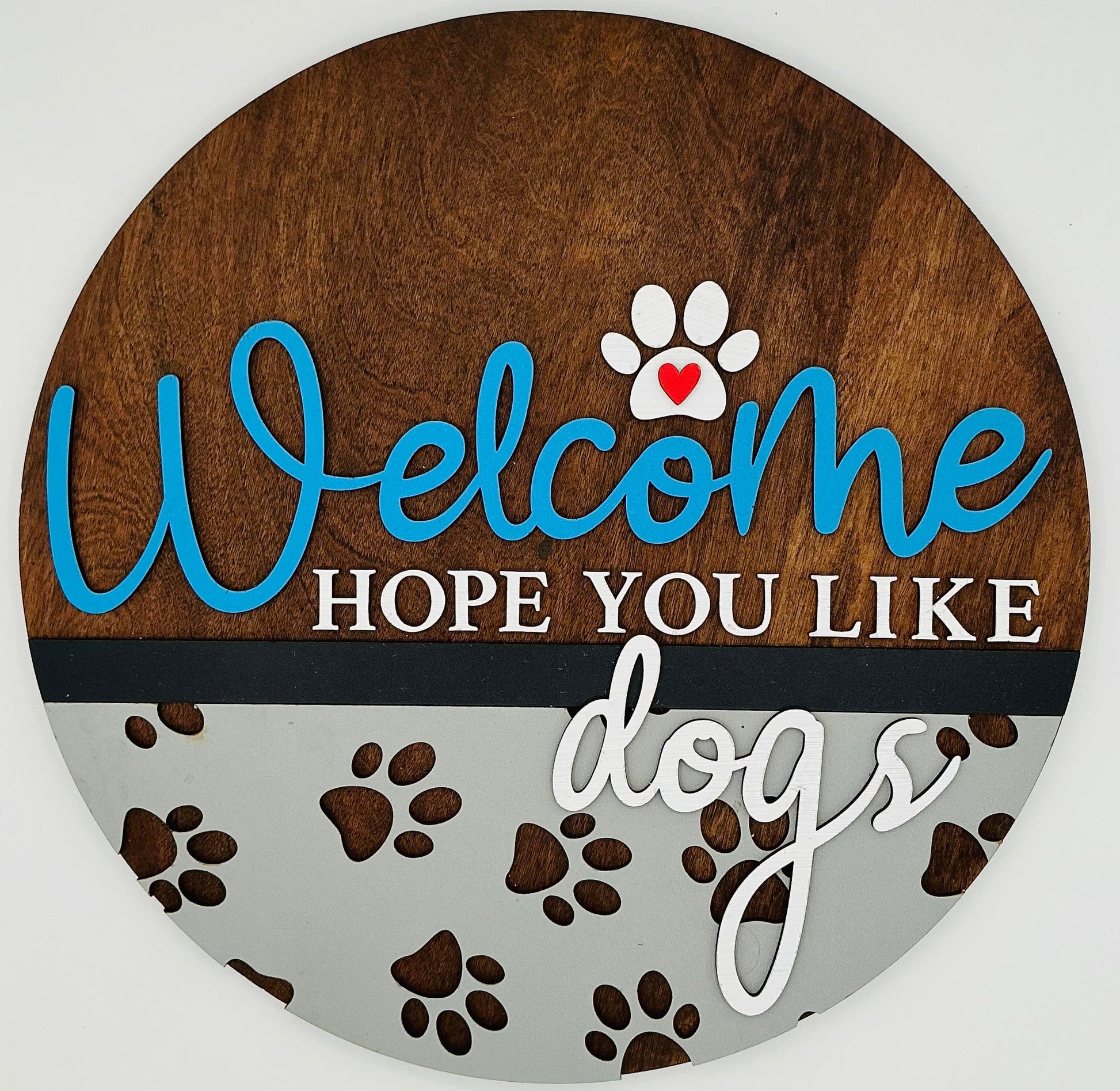 Round wooden sign with 'Welcome Hope You Like Dogs' text and paw prints on a white background