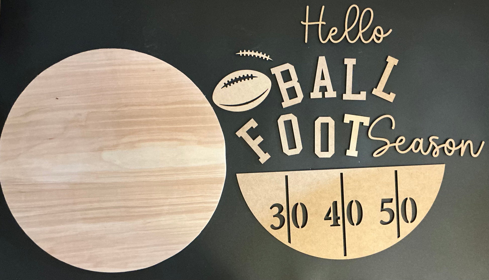Wooden sign with 'Hello Ball Foot Season' text and football graphic on a dark background