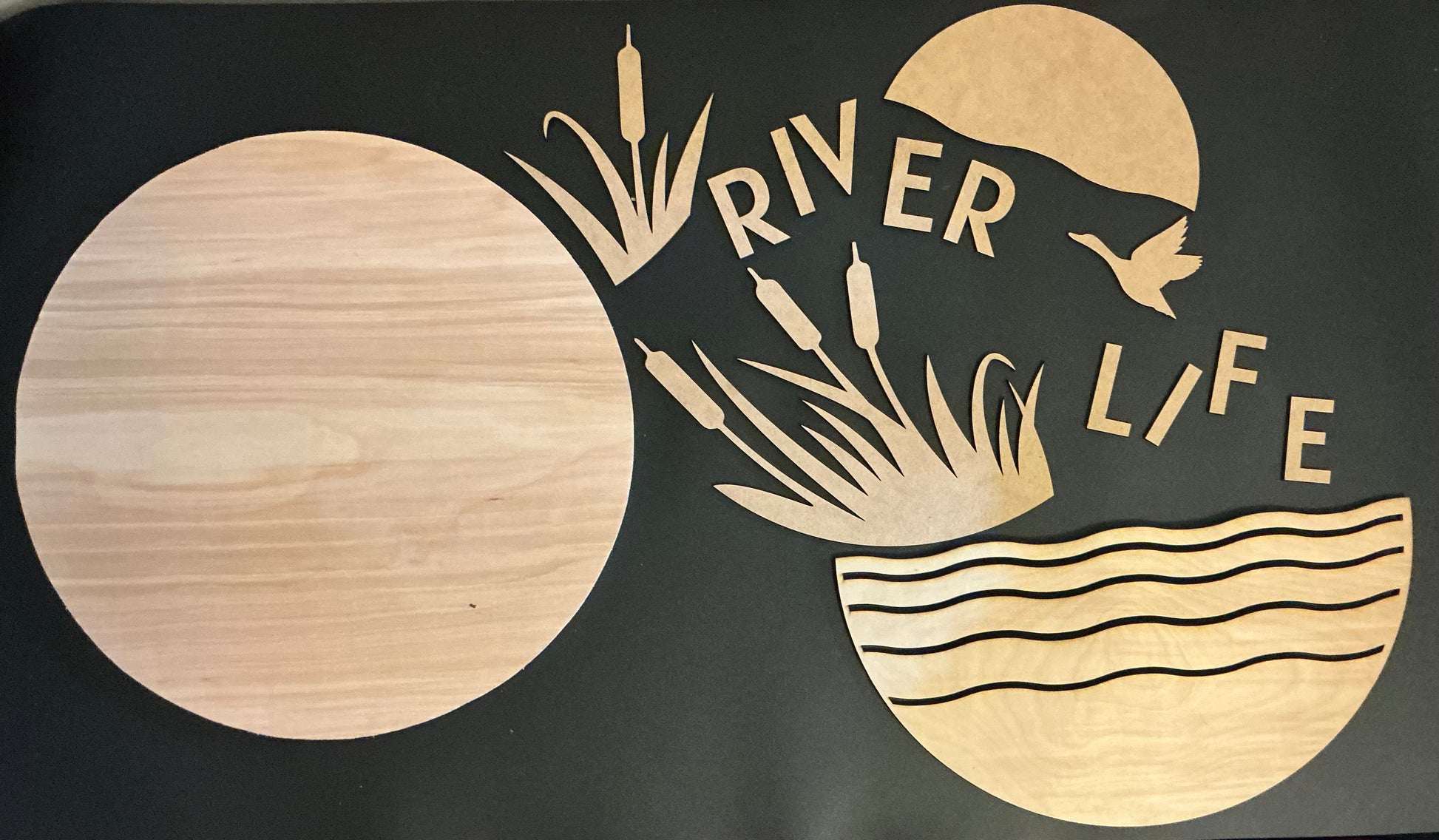 Decorative wall art with 'River Life' text and nature elements on a black background